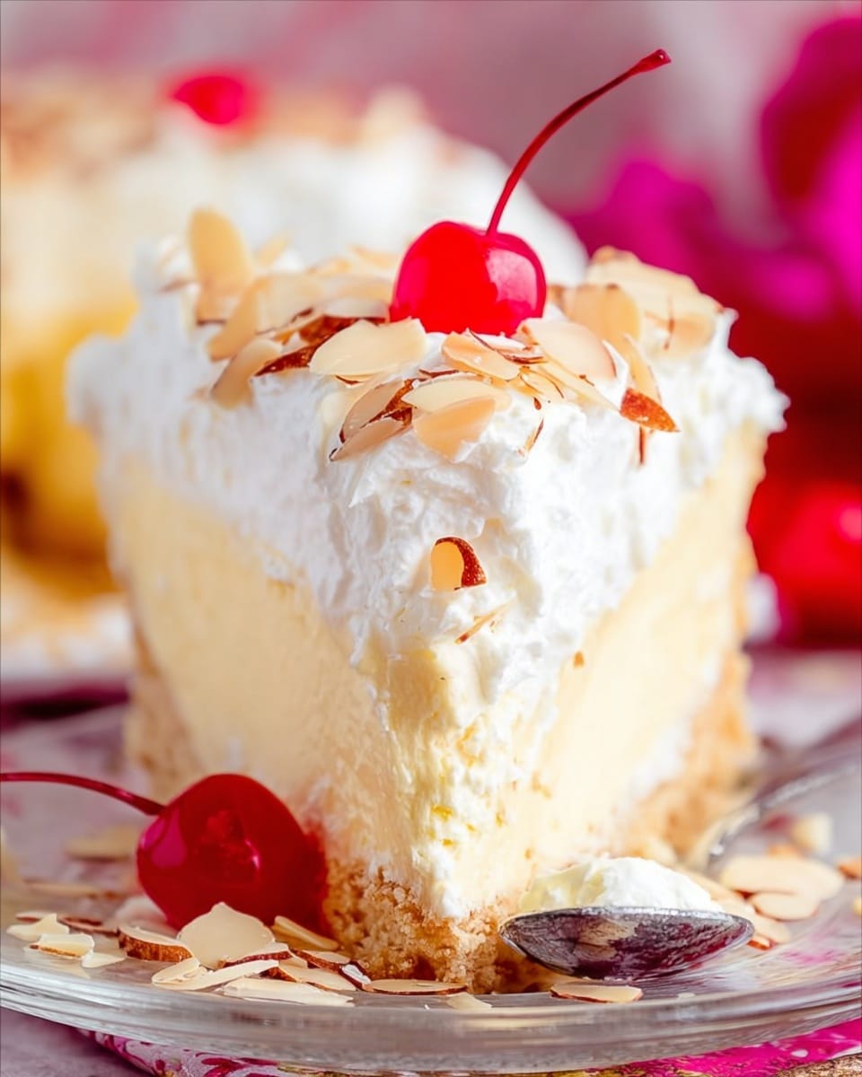 The image shows a thick slice of light yellow cake with a crumbly beige crust at the bottom, topped with a thick layer of white whipped cream sprinkled with thin, toasted almond slices. A bright red cherry with its stem sits on top of the whipped cream, adding a pop of color. Another cherry lies on the white marbled surface beside the clear glass plate holding the cake. A silver fork rests on the plate, with a scoop of the cake and whipped cream on the fork’s tip. The background is soft and blurry, focusing attention on the creamy texture of the cake and the glossy cherries. Photo taken with an iphone --ar 4:5 --v 7
