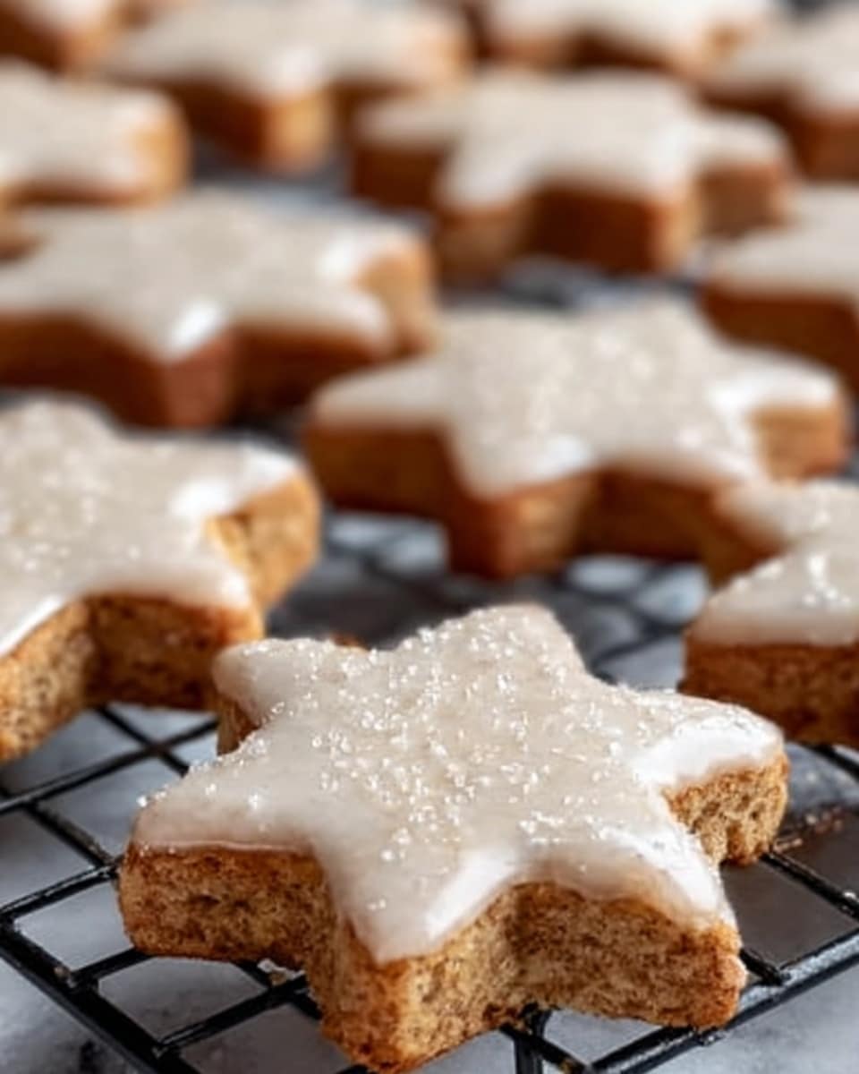 The image shows a close-up of several star-shaped cookies on a black wire cooling rack. The cookies have a light brown color with a slightly rough texture, and they are topped with a smooth, white icing that is slightly glossy. One cookie in the foreground is being held by a woman's hand, showing the thickness and details of the icing, which has a soft, creamy look with a few shiny spots. The background is softly blurred, highlighting the cookies in sharp focus. Photo taken with an iphone --ar 4:5 --v 7