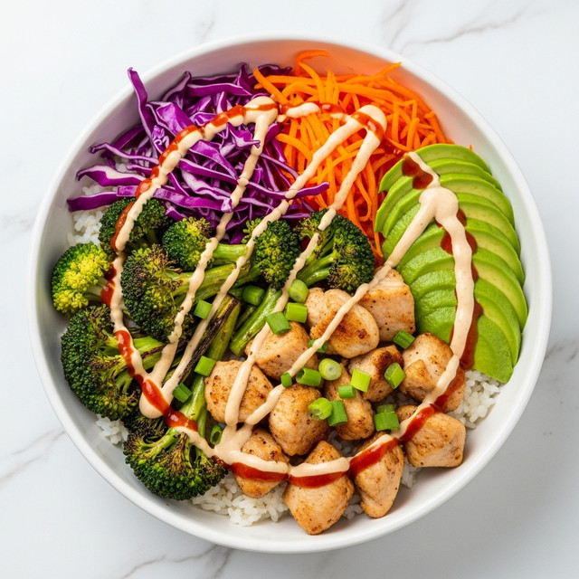 A white bowl filled with white rice at the bottom, topped with grilled chicken pieces in the center, covered with a light tan sauce and dotted with red chili sauce, garnished with chopped green onions. On the left side, there is shredded purple cabbage, and on the right side, slices of bright green avocado resting partly on the rice. Below the avocado, orange shredded carrots sit beside vibrant green broccoli heads. A woman's hand is holding the bowl slightly from the left side. The bowl rests on a white marbled surface. photo taken with an iphone --ar 4:5 --v 7