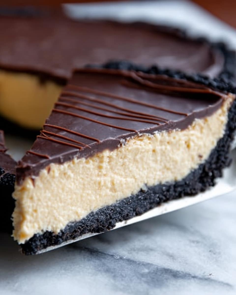 A close-up image of a sliced chocolate tart with three distinct layers. The bottom layer is a dark chocolate crumb crust with a rough texture. The middle layer is a thick, creamy light beige filling, smooth and dense. The top layer is a shiny, dark chocolate glaze with fine lines from slicing on the surface, giving it a glossy look. The tart is placed on a white marbled surface, with a metal spatula partially visible under the slice. Photo taken with an iphone --ar 4:5 --v 7